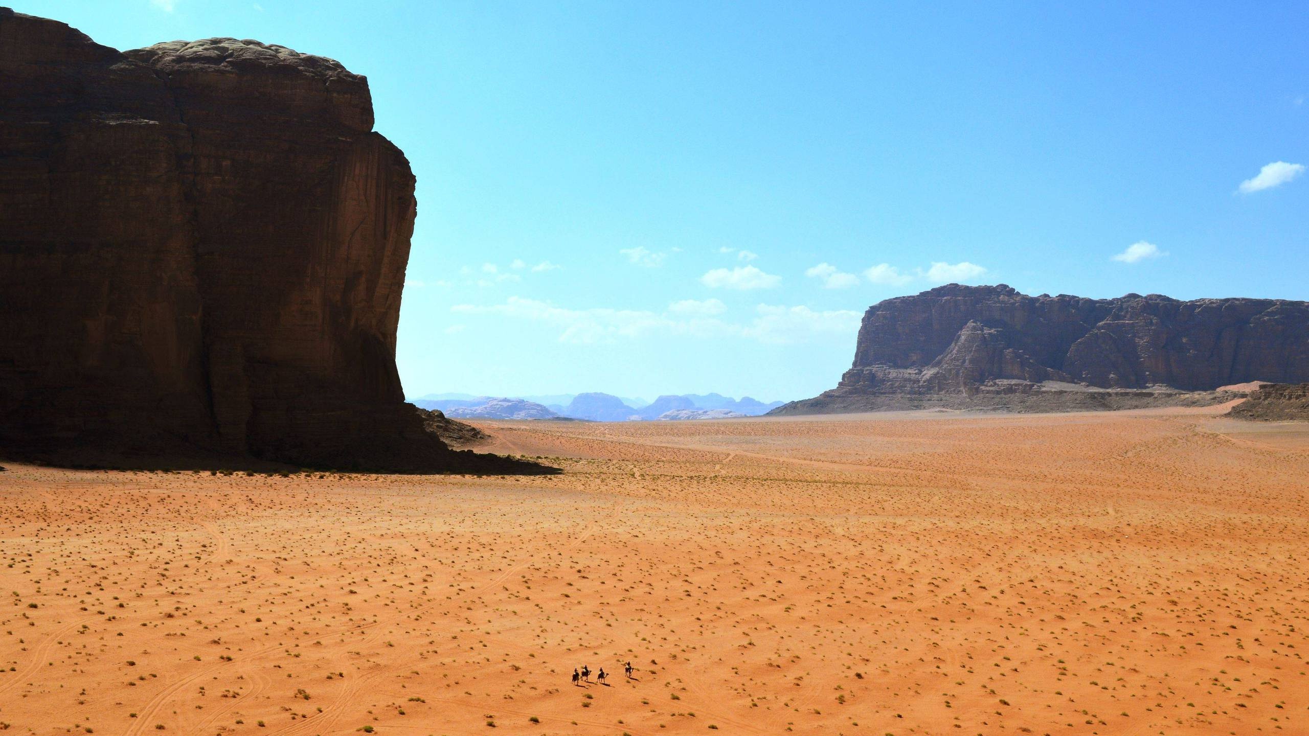 Wadi Rum Village, Vast sandstone cliffs, Ancient rock carvings, Magical desert, 2560x1440 HD Desktop