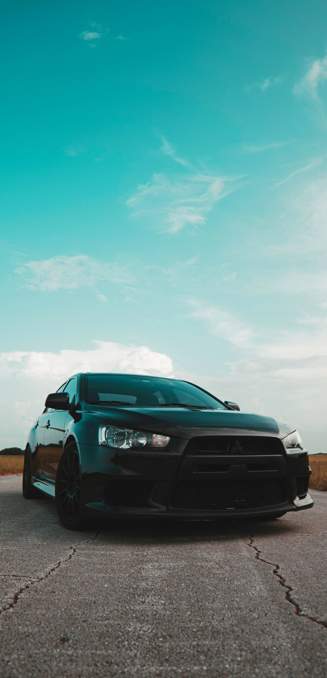 Mitsubishi Lancer wallpaper, Black matte Lancer, Skyline backdrop, Sports car aesthetics, 1080x2240 HD Phone